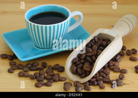 Coffee beans on wooden wooden scoop and coffee in vintage cup Stock Photo