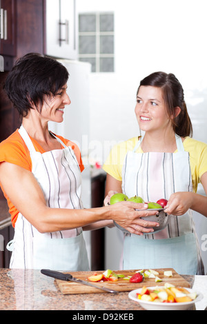 teen girl helping mother in home kitchen Stock Photo