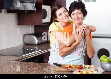 middle aged mother and teen daughter in kitchen Stock Photo