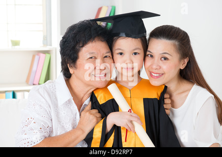 Kindergarten graduation. Happy Asian family, grandparent, parent and grandchild on her kindergarten graduate day. Stock Photo