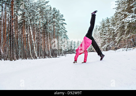 A woman doing a cartwheel in the snow Stock Photo