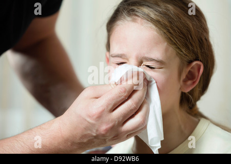 Father wiping daughter's nose with tissue Stock Photo