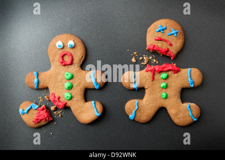 A shocked gingerbread man with broken leg next to a decapitated gingerbread man Stock Photo