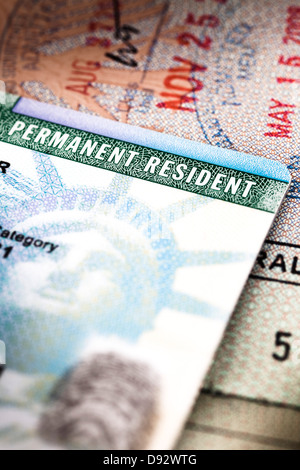 A Green Card lying on an open passport, close-up, full frame Stock Photo