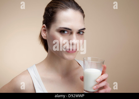 A smiling young woman holding a glass of milk Stock Photo
