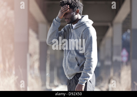 A man with his hand on his forehead with a look of dejection Stock Photo