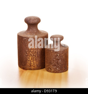 Closeup of two old rusty weights with five and two kilograms on wooden floor Stock Photo