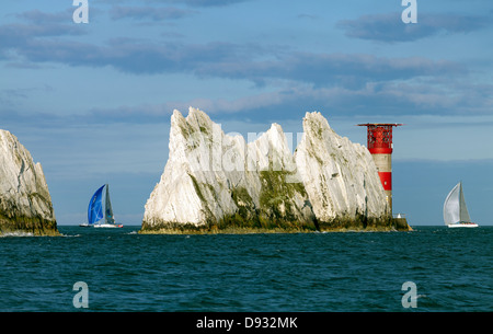 Between a rock and a hard place white sails sailing past the Needles Lighthouse Isle of Wight Stock Photo