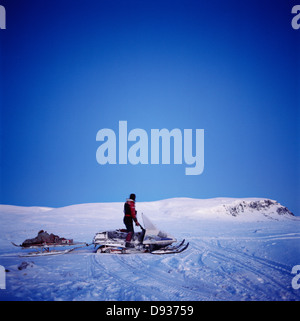 Man driving sledge on snowy ground, side view Stock Photo