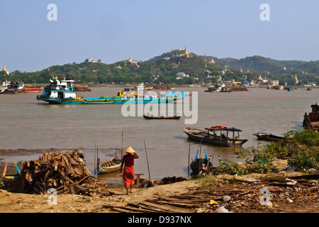 Boat traffic on the IRRAWADDY RIVER with SAIGAING HILL behind - MANDALAY, MYANMAR Stock Photo