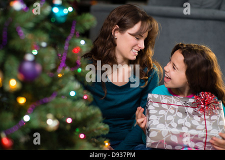 Hispanic mother and daughter opening Christmas presents Stock Photo
