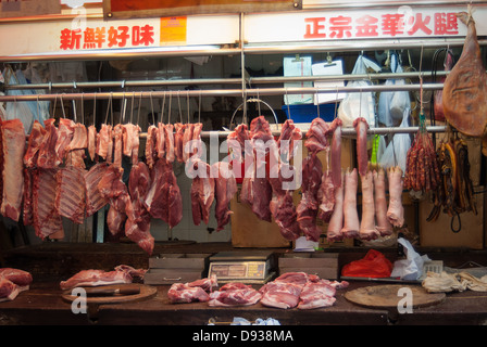 Chinese butcher at work preparing meat for sale at a market in Hong ...