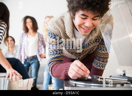 Man putting on record in living room Stock Photo