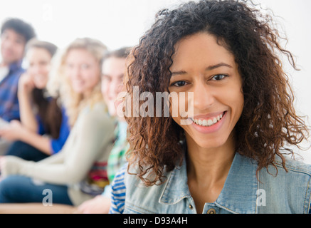 Smiling woman sitting on sofa Stock Photo