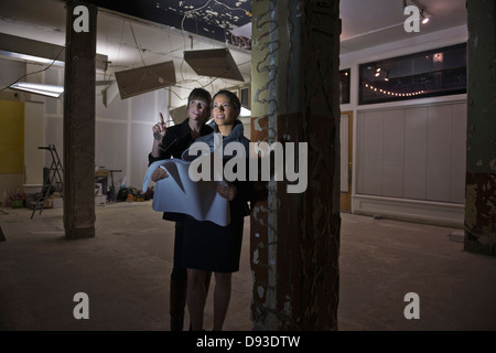 Business people reading blueprints in building Stock Photo