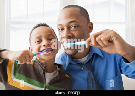 Father and son brushing their teeth Stock Photo