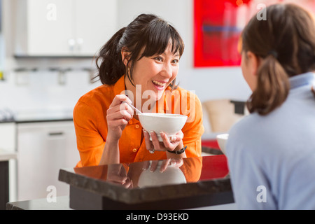 Mother and daughter talking in kitchen Stock Photo