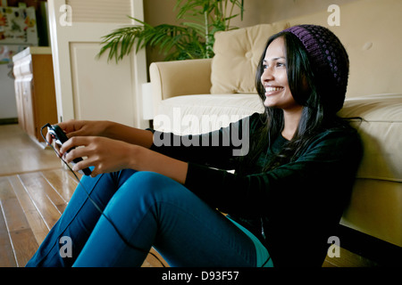 Indian woman playing video games in living room Stock Photo