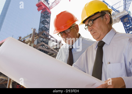Hispanic businessmen reading blueprints Stock Photo