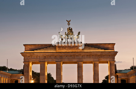 Columned building and statue lit up at night, Berlin, Germany Stock Photo