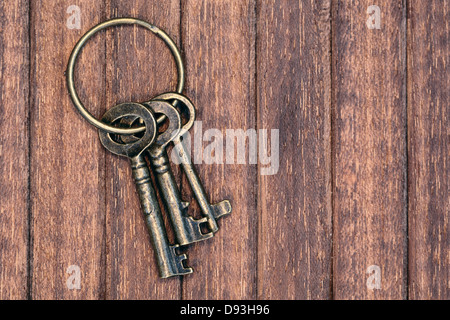 three old keys on a wooden background Stock Photo