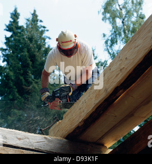 Carpenter cutting wooden plank Stock Photo