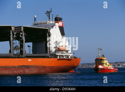 Tug boat towing ship Stock Photo