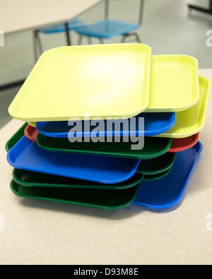 A pile of coloured trays in a school canteen Stock Photo