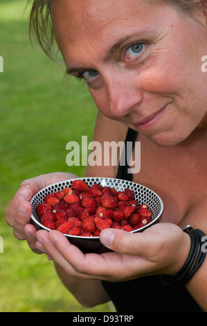 Mature woman holding bowl of strawberry Stock Photo