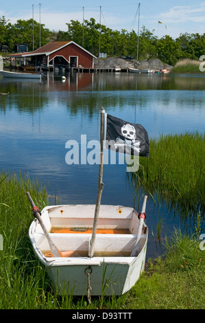 Flag with skull and crossbones on boat next to sea Stock Photo