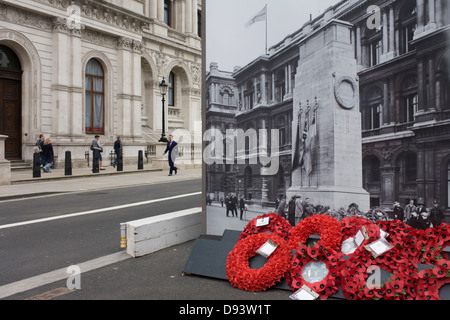 Real remembrance wreaths on the ground at the foot of a black and white vintage era photograph that shows the Cenotaph, currently hiding the real monument being renovated in London's Whitehall. In a landscape of false perspective and confusing juxtapositions between reality and the reproduction of the picture, we see the famous war memorial in central London. Stock Photo