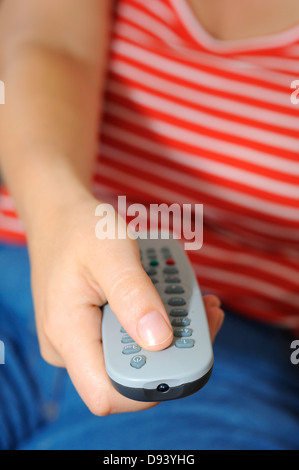 Close-up of womans hand holding remote control Stock Photo