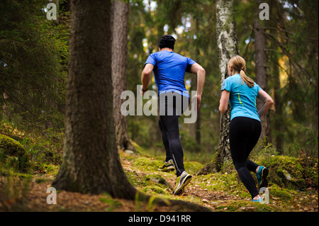 Young couple jogging in forest Stock Photo