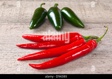 Red and Green Chilli Peppers on Weatherd Wood - red and green (jalapeno) chillis on a weathered wooden surface. Stock Photo
