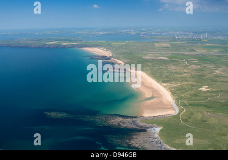Aerial view of Freshwater West beach with Milford Haven and Rhoscrowther refinery in background Pembrokeshire West Wales UK