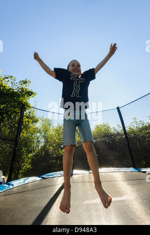 Happy boy jumping on trampoline