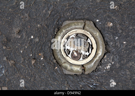 item embedded in hot tarmac road surface in sun Stock Photo