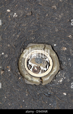 item embedded in hot tarmac road surface in sun Stock Photo