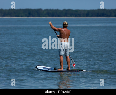 Stand Up Paddle Boarding. Stand Up Paddle Boarding is a fast growing water sport with roots in Hawaiian surfing techniques. Stock Photo