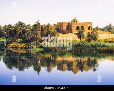 A home on the banks of the river Nile surrounded by palm trees and reflected in the waters Stock Photo