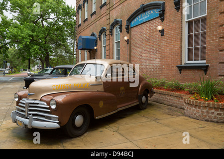 Vintage police patrol cars on display outside the historic Savannah Chatham Metropolitan Police Barracks building. Stock Photo