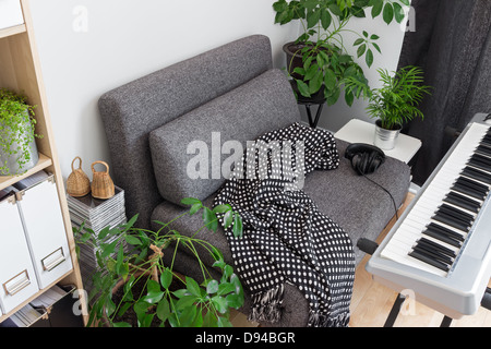 Comfortable place for a musician. Armchair and electric piano. Stock Photo