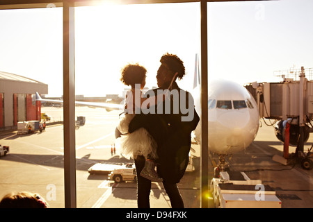 Mother holding daughter at airport Stock Photo