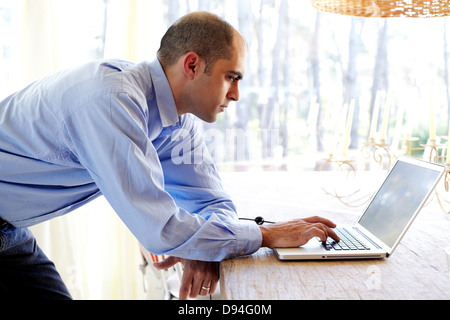 Mixed race businessman using laptop in office Stock Photo
