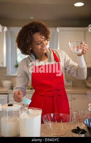 Mixed race woman baking in kitchen Stock Photo