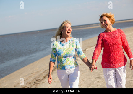 Caucasian women walking on beach Stock Photo