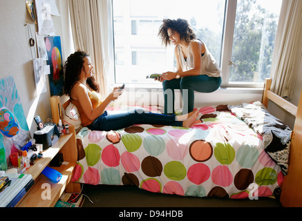 Mixed race college students relaxing in dorm Stock Photo