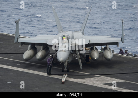 US Navy sailor refuels an F/A-18E Super Hornet fighter aircraft on the flight deck of the aircraft carrier USS Nimitz May 22, 2013 operating in the South China Sea. Stock Photo