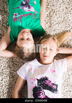 Young Girls Lying Down on a Carpet in Studio Stock Photo