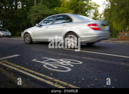 a car speeds by a cycle lane Stock Photo